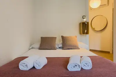 a bedroom with a bed with three towels on it at Plaza España 238 in Barcelona