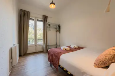 a bedroom with a bed and a large window at Plaza España 238 in Barcelona