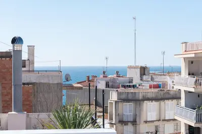 a view of the ocean from the roofs of buildings at Hauzify I Apartaments Voramar in San Pol de Mar