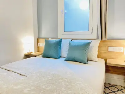 a bedroom with a bed with two blue pillows at Lazy Donkey Sagrada Familia in Barcelona