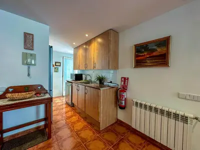 a kitchen with wooden cabinets and a counter top at Sira House by Hello Homes Sitges in Sitges