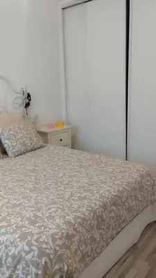 a bedroom with a bed with a gray and white bedspread at Casa dess in Hospitalet de Llobregat