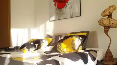 a bedroom with a bed with yellow and black pillows at ALEXANDRA´s BEACH-PORT in Badalona