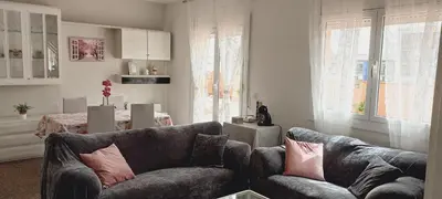 a living room with two couches and a table at Cozy and sunny penthouse Fira BCN in Hospitalet de Llobregat