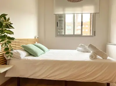 a large white bed with two pillows and a window at Playa, piscina, parking GENIAL in Cubelles