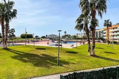 a park with palm trees and a pool at Playa, piscina, parking GENIAL in Cubelles