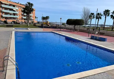 a large blue swimming pool next to a building at Playa, piscina, parking GENIAL in Cubelles