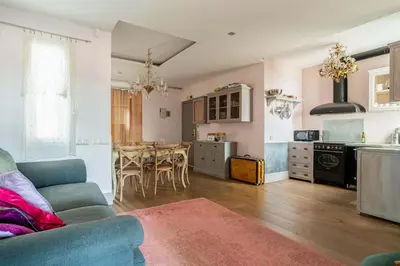 a living room with a blue couch and a kitchen at Canela Homes BARCELONA SEPULVEDA in Barcelona