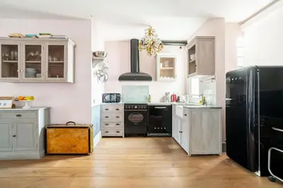 a kitchen with white cabinets and a black refrigerator at Canela Homes BARCELONA SEPULVEDA in Barcelona