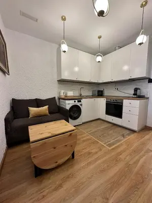 a living room with a couch and a kitchen at MI CASA ES TU CASA in Hospitalet de Llobregat