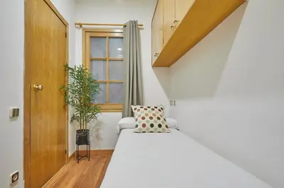 a bedroom with a white bed and a window at BBarcelona Gràcia Nova Flat in Barcelona