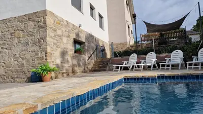 a swimming pool with chairs next to a building at Cal Sidru Castellolí in Castellolí