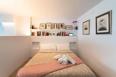 a bedroom with a bed and shelves on the wall at Sitges Beach Hostal in Sitges