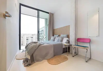 a bedroom with a bed and a large window at En Ville Boutique Apartments Sant Antoni in Barcelona