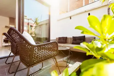 a living room with wicker chairs and a couch at En Ville Boutique Apartments Sant Antoni in Barcelona