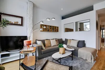 a living room with a couch and a tv at En Ville Boutique Apartments Sant Antoni in Barcelona