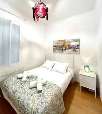 a bedroom with a bed and a chandelier at Apartment carrer d'Olesa in Barcelona