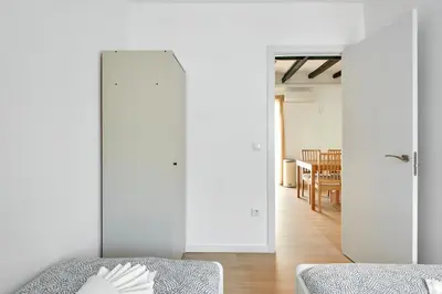 a white room with a bed and a dining room at Ma Bright apartment next to Parc de Montjuïc in Barcelona