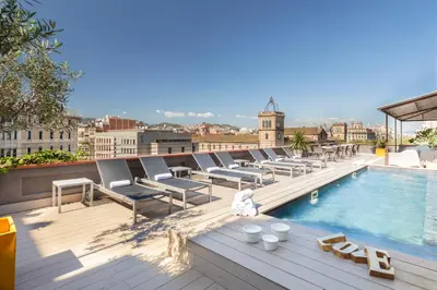 a rooftop deck with lounge chairs and a swimming pool at Enjoybcn Miro Apartments in Barcelona