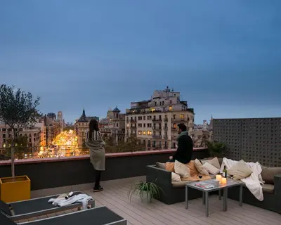 a man and woman standing on the roof of a building at Enjoybcn Miro Apartments in Barcelona