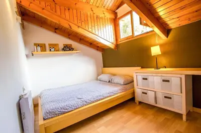a small bedroom with a bed and a window at Swiss style villa near Barcelona 10min to beach in Sant Cebrià de Vallalta