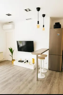 a living room with a table and a refrigerator at Apartamento Sol Terraza in Montgat