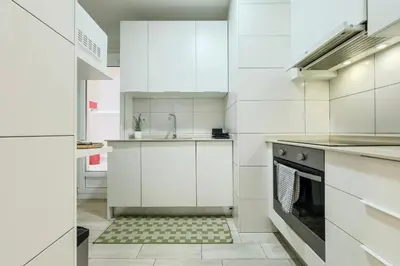 a kitchen with white cabinets and an oven at Barcelona Aura Apartments in Hospitalet de Llobregat