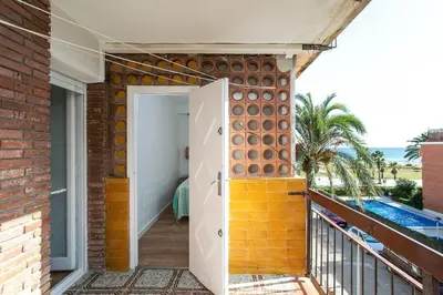 a balcony with a brick wall and a door at Canela Homes COSTA CALMA in Castelldefels