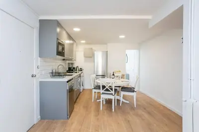a kitchen and dining room with a table and chairs at Canela Homes COSTA CALMA in Castelldefels