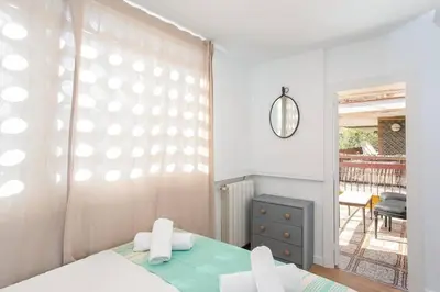 a bedroom with a bed and a window with a balcony at Canela Homes COSTA CALMA in Castelldefels
