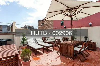 a patio with a table and chairs and an umbrella at Canela Homes BARCELONA BORN in Barcelona