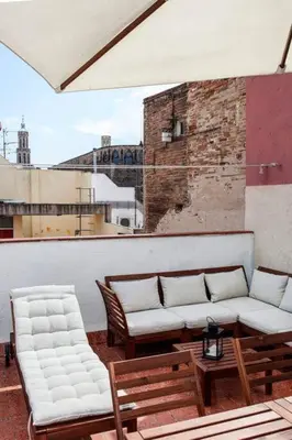 a balcony with two couches and a table and chairs at Canela Homes BARCELONA BORN in Barcelona