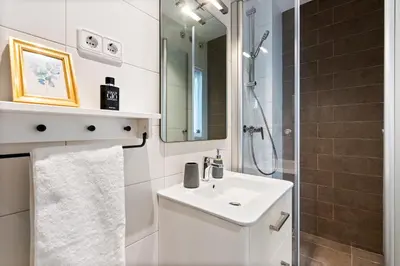 a white bathroom with a sink and a shower at Lodging Apartments Almirall Beach 41 in Barcelona
