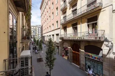 a city street with buildings and people walking on the sidewalk at Canela Homes BARCELONA JOVELLANOS in Barcelona