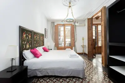 a bedroom with a large white bed with pink pillows at Canela Homes BARCELONA JOVELLANOS in Barcelona