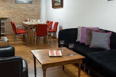 a living room with a couch and a table with wine glasses at Canela Homes BARCELONA JOVELLANOS in Barcelona