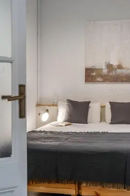 a bedroom with a bed with a black blanket and pillows at Canela Homes BARCELONA ESSENCE in Barcelona