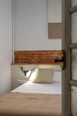 a bedroom with a bed with a brick wall at Canela Homes BARCELONA ESSENCE in Barcelona