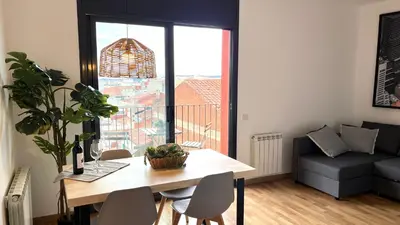 a living room with a table and a large window at APARTAMENTO CON TERRAZA BY PRESTIGI in Terrassa