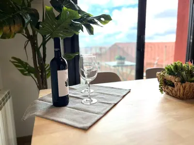 a bottle of wine sitting on a table with a glass at APARTAMENTO CON TERRAZA BY PRESTIGI in Terrassa