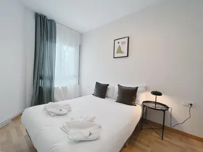 a white bed in a room with a window at Stay U-nique Apartment General Mitre in Barcelona