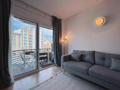 a living room with a couch and a large window at Stay U-nique Apartment General Mitre in Barcelona
