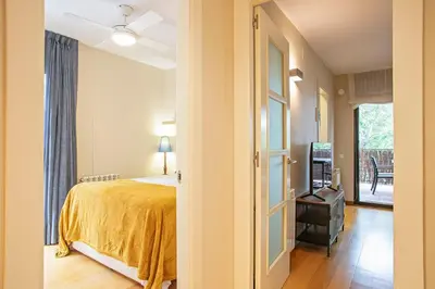 a bedroom with a bed with a yellow bedspread at Winahost La Terraza de Sant Cugat in Sant Cugat del Vallès