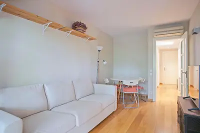 a living room with a white couch and a table at Winahost La Terraza de Sant Cugat in Sant Cugat del Vallès