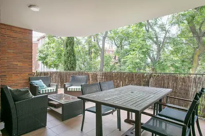 a wooden table and chairs on a patio at Winahost La Terraza de Sant Cugat in Sant Cugat del Vallès