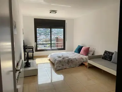 a bedroom with a bed and a window and a couch at Habitaciones en Villa Coliving Villa Vistas in San Fausto de Campcentellas