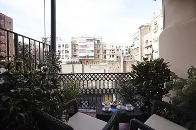 a balcony with a table and chairs and plants at Close to Passeig de Gracia in Barcelona