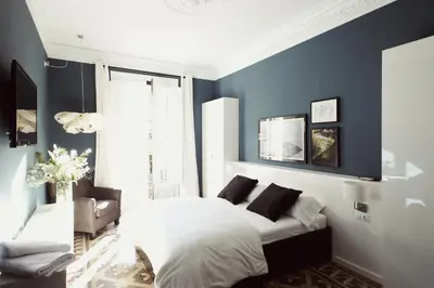 a bedroom with blue walls and a bed and a chair at Close to Passeig de Gracia in Barcelona