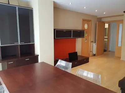 a kitchen with a table and chairs and a room at Pis de bon disseny i sostenible. in Manresa