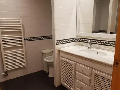 a bathroom with a sink and a toilet and a mirror at Pis de bon disseny i sostenible. in Manresa